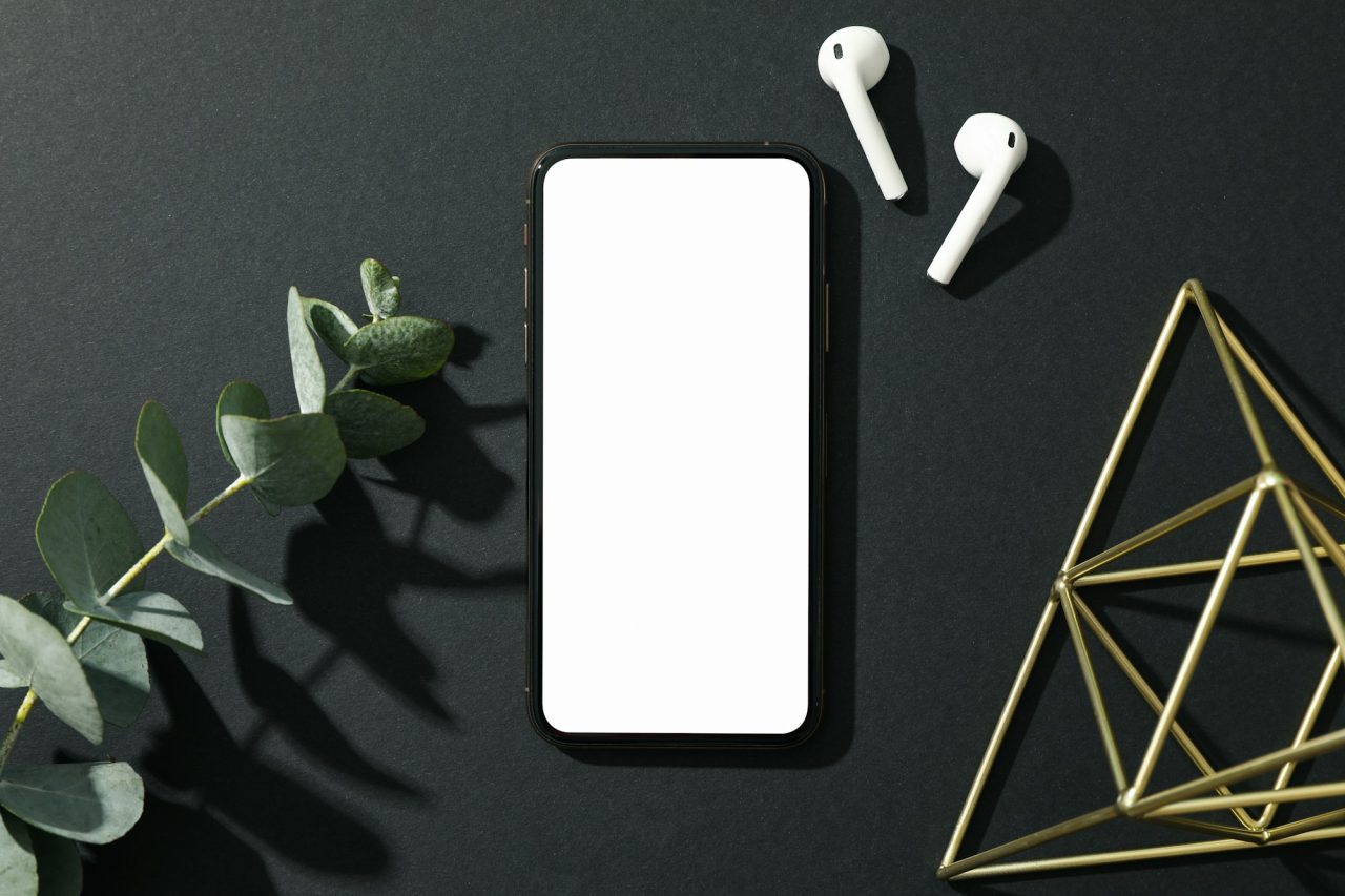 phone with empty screen on black decorated background top view